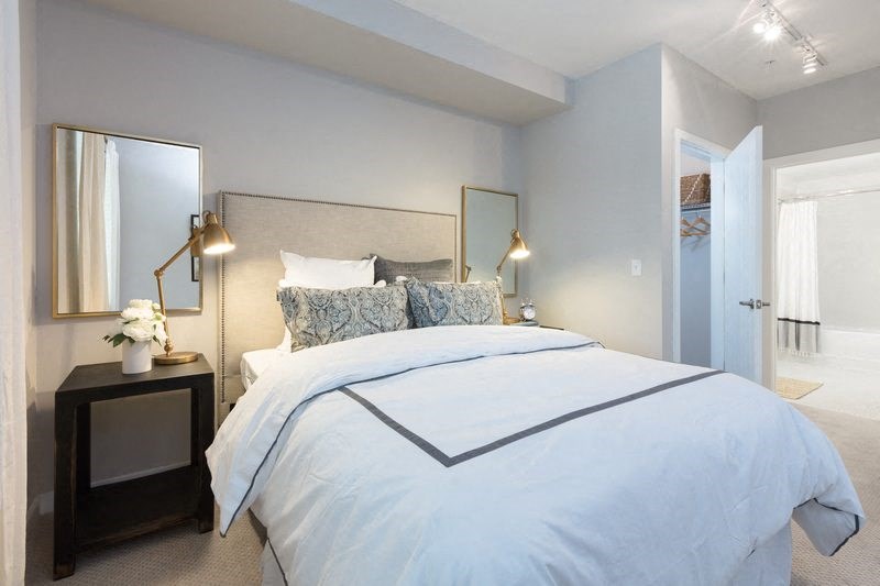 a bedroom with a large bed and a mirror