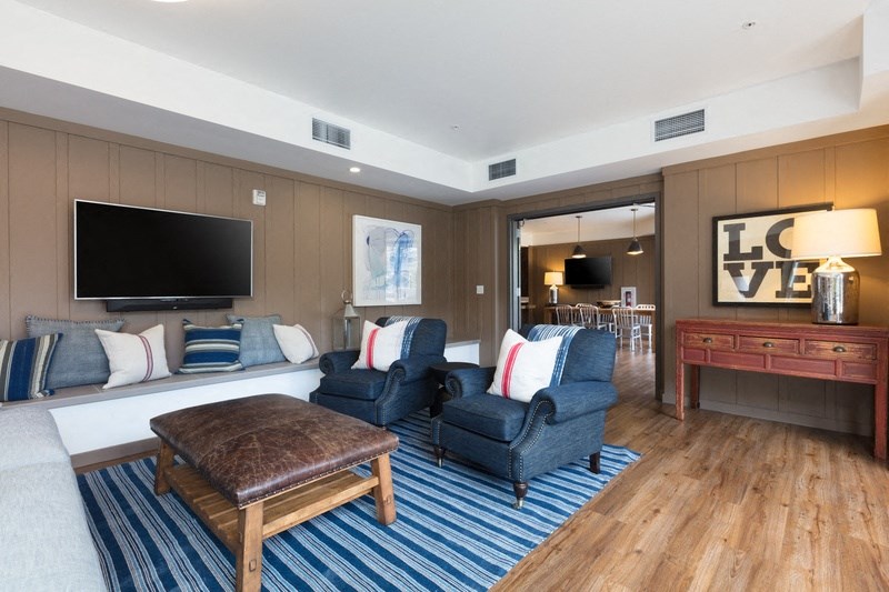 a living room with a couch and chairs and a television