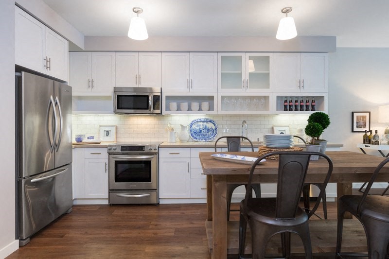 a kitchen with stainless steel appliances and a wooden table
