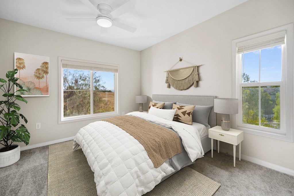 A bedroom with a large bed and a ceiling fan.