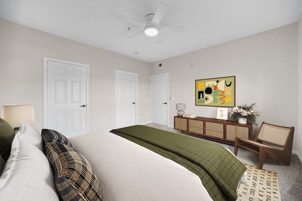 A bedroom with a bed, a bench, and a painting on the wall.