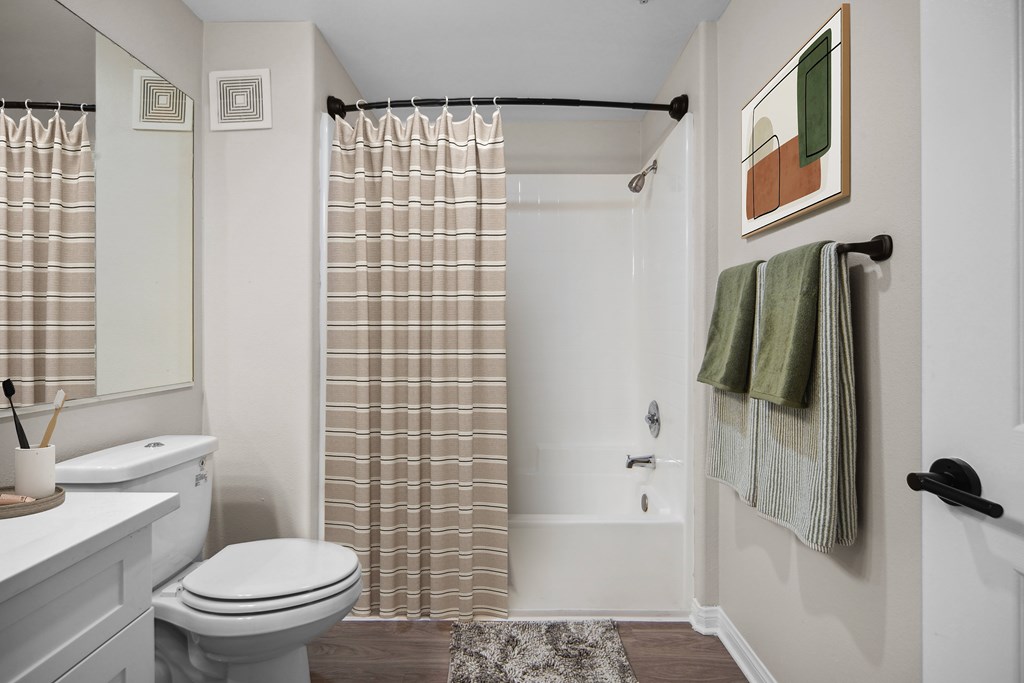 A bathroom with a toilet, sink, and shower.