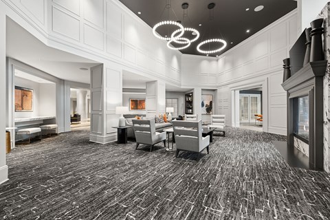 A large, well-lit room with a grey carpet and furniture.