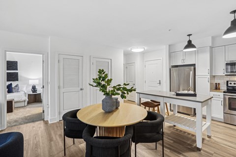 a living room with a table and chairs and a kitchen