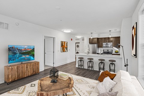a living room with a couch and a table and a kitchen