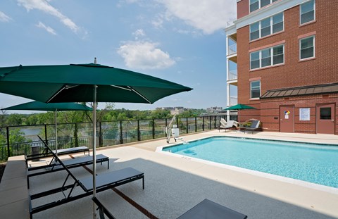 a swimming pool with chairs and umbrellas
