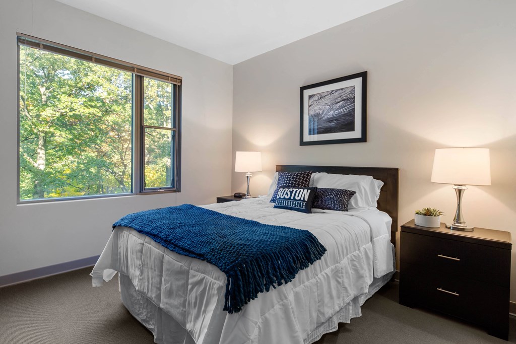 a bedroom with a bed and a large window