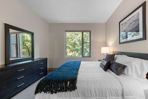 A bedroom with a large bed and a window.