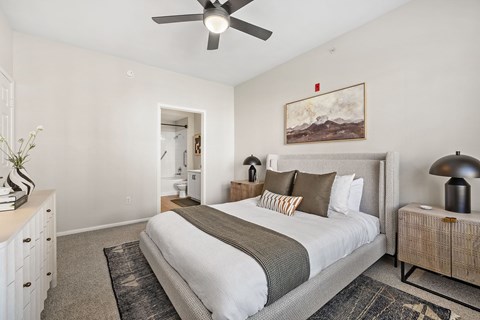 A bedroom with a large bed and a painting on the wall.
