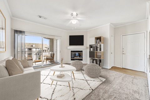 A living room with a grey carpet and a white sofa.