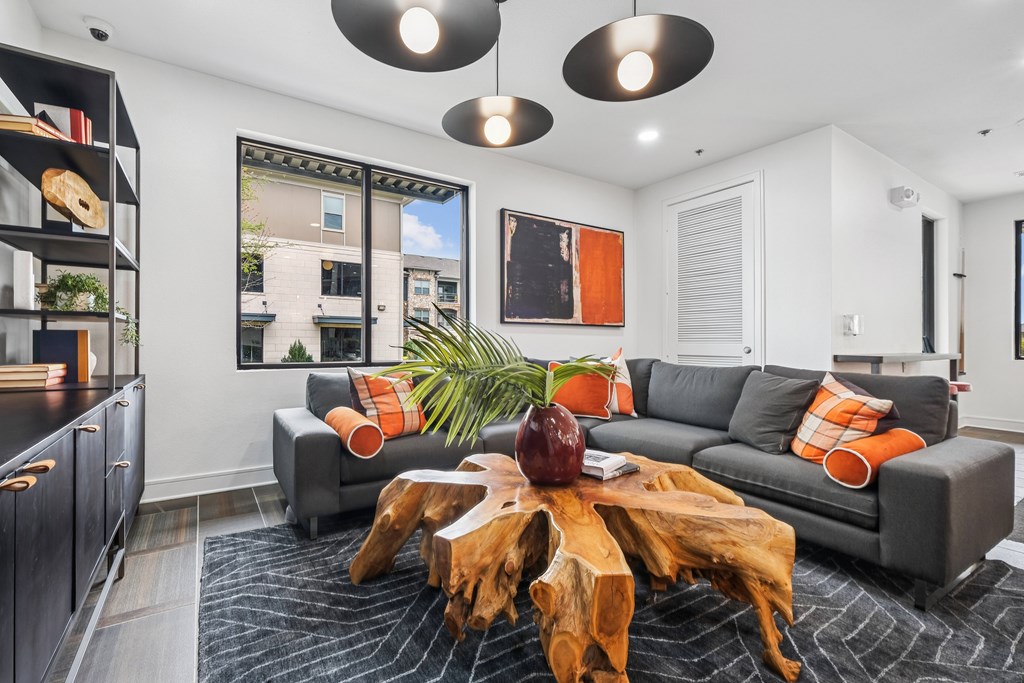 A living room with a grey couch and a wooden coffee table.