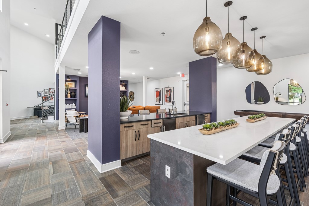 A modern kitchen with a long island and bar stools.