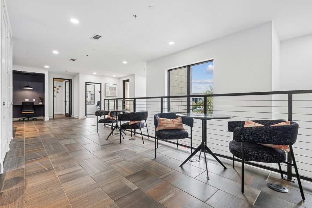 A modern living room with a black railing and a wooden floor.