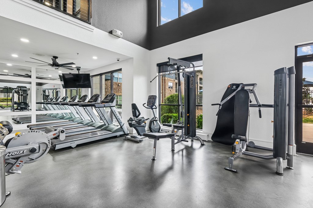 A gym with treadmills, elliptical machines, and other exercise equipment.
