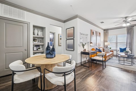 A modern living room with a round wooden table and chairs.