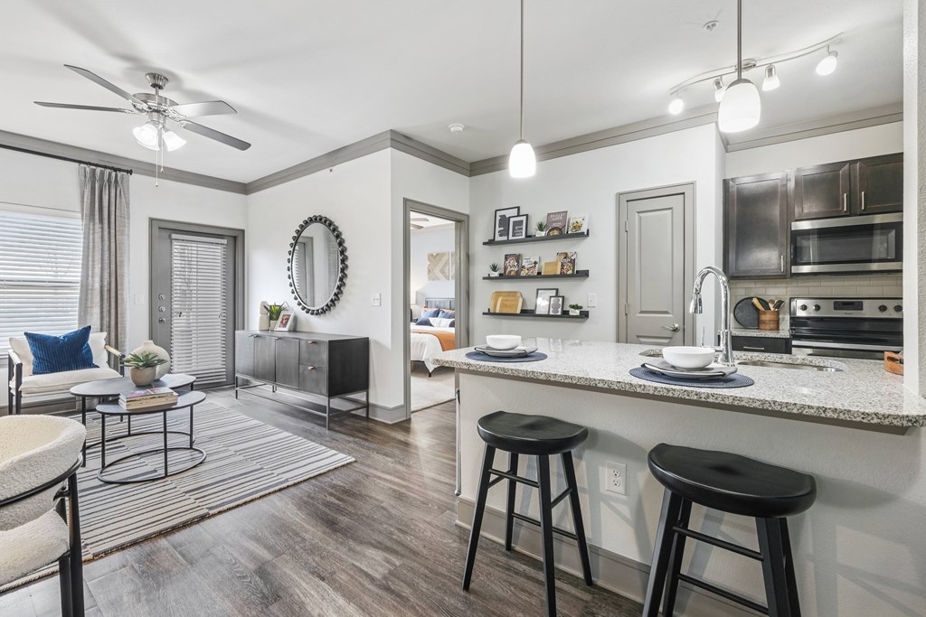 A modern kitchen with a bar stool and a dining table.