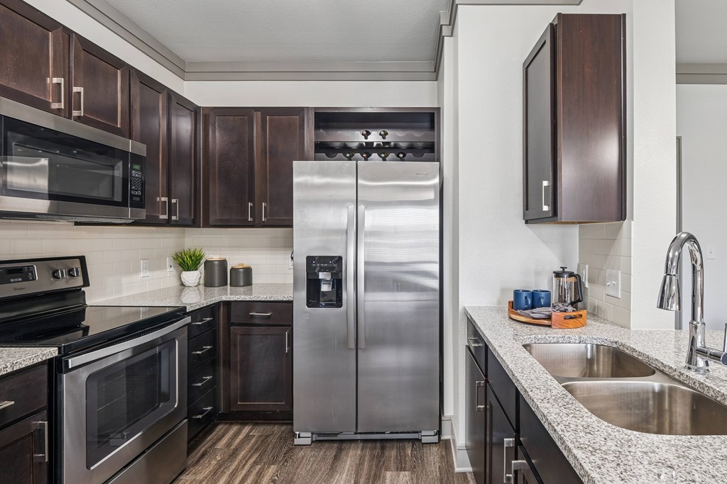 A modern kitchen with a stainless steel refrigerator and wooden cabinets.