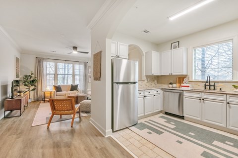 A modern kitchen with white cabinets and a refrigerator.