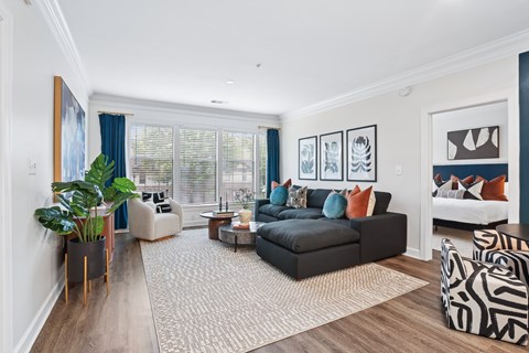 A living room with a black couch and a zebra print chair.