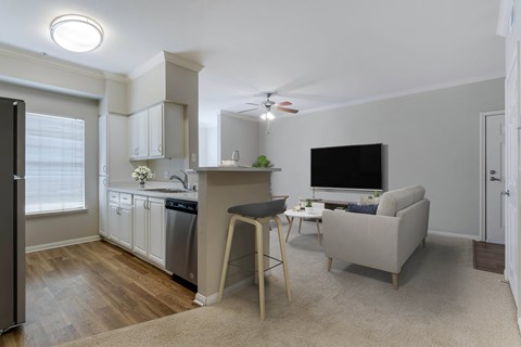 a living room with a couch and a chair and a kitchen with a counter top