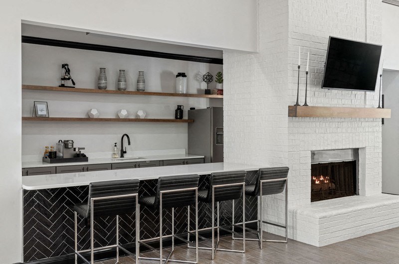 a kitchen with a fireplace and a bar with stools