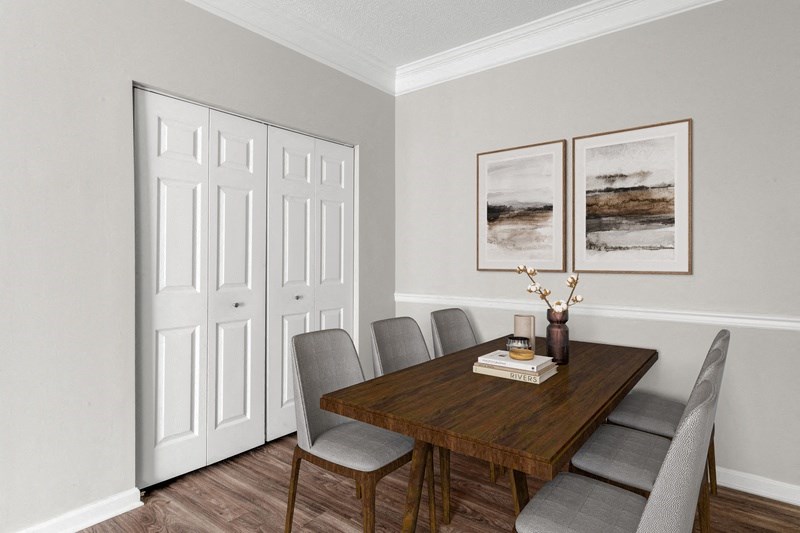 a dining room with a table and chairs and two paintings on the wall