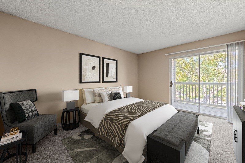 a bedroom with a bed and a chair next to a sliding glass door