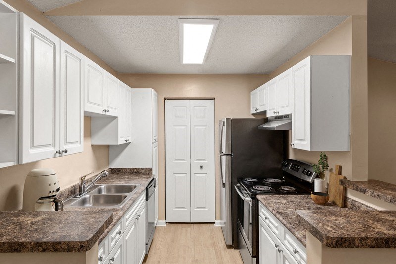 a kitchen with white cabinets and a black stove top oven