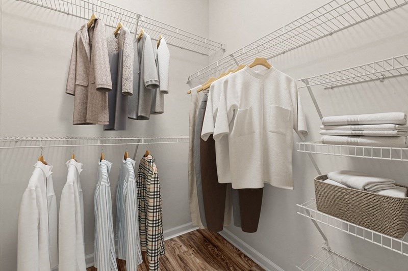 a walk in closet with a white closet organizer and wire shelves