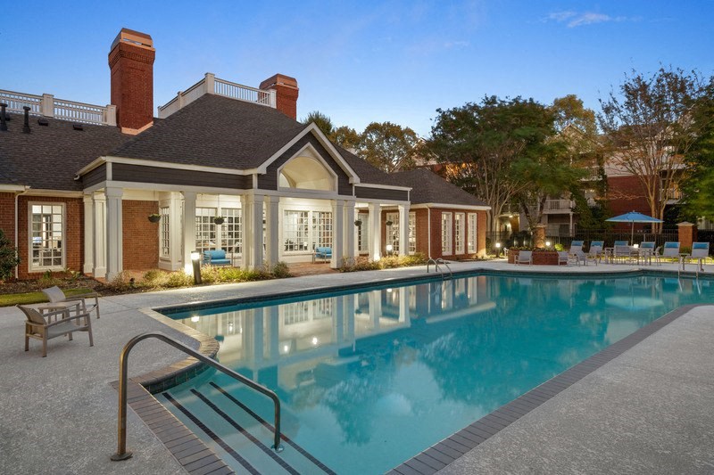 a swimming pool with a house in the background