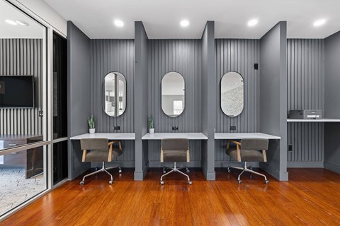 A modern office space with grey walls and wooden floors.