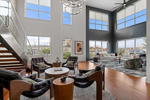 A living room with a staircase and a chandelier.