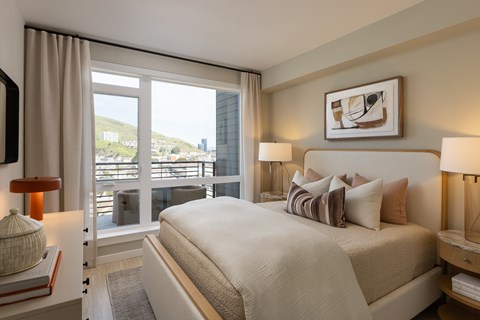 A bedroom with a large bed and a view of the city.