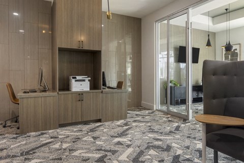 an office with a desk and a printer in a room with a glass door