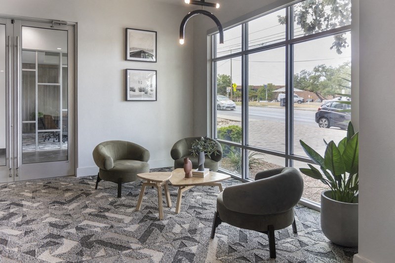 a living room with chairs and a table and a large window