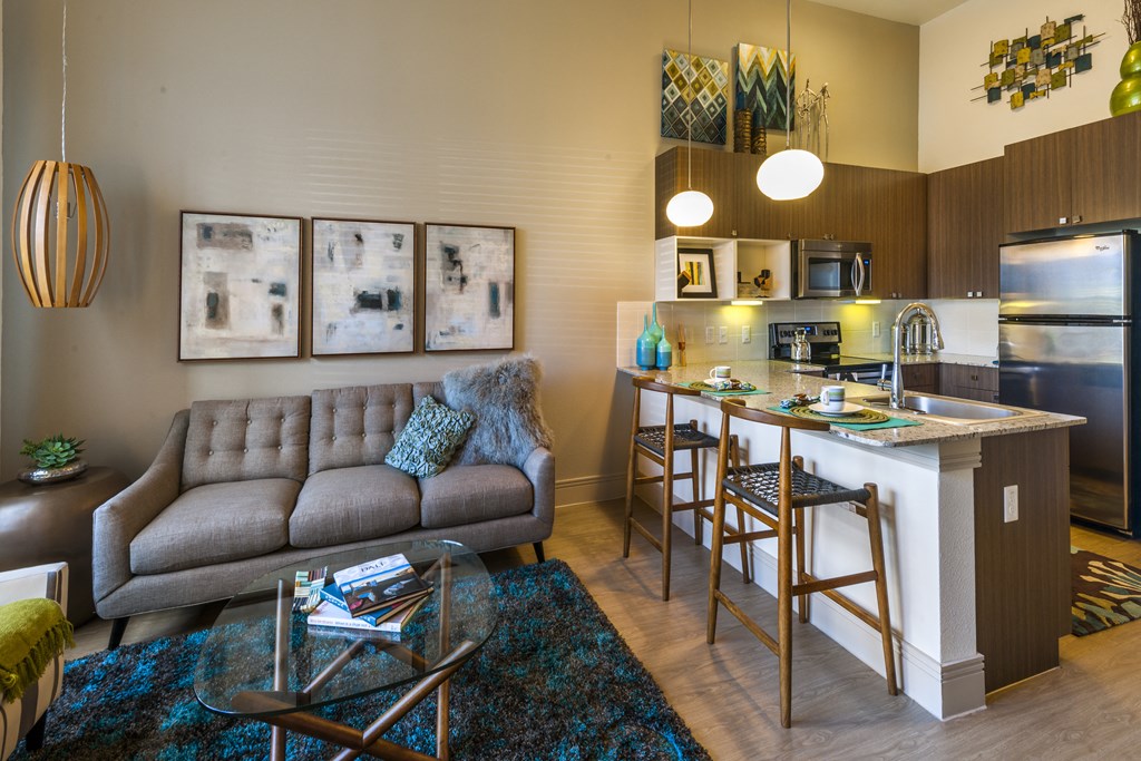 a living room with a couch and a kitchen with a bar