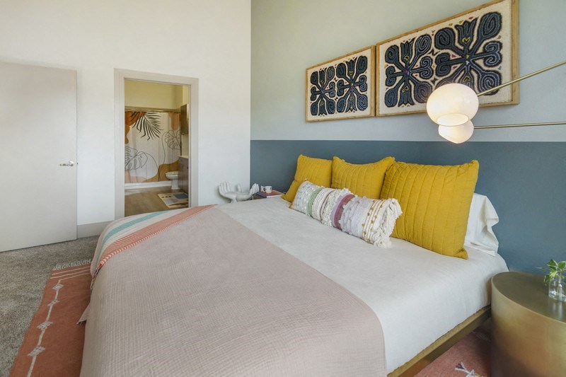 a bedroom with a white bed and yellow pillows