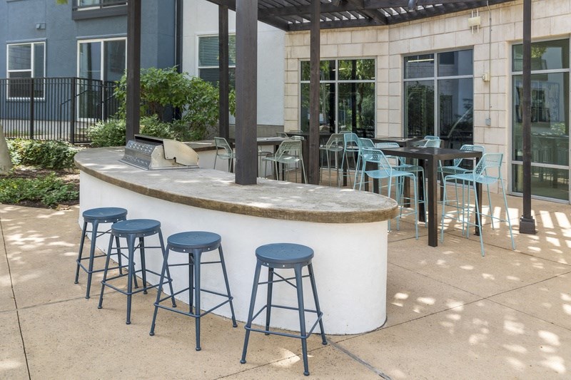 a bar with blue bar stools and chairs around it