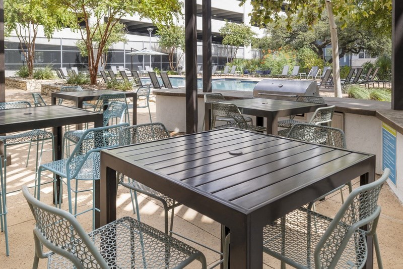 a patio with tables and chairs and a pool