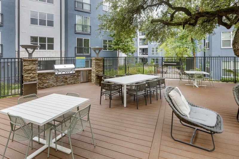 a patio with tables and chairs on a deck