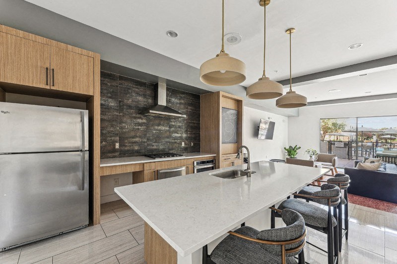 the kitchen has a large island and stainless steel appliances