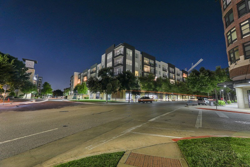 a city street at night with tall buildings