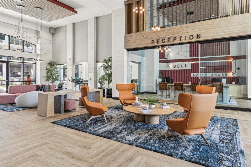 a lobby of a hotel with a reception desk and chairs