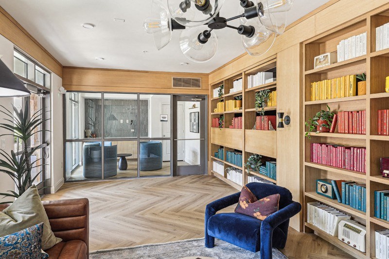 a library with a seating area and a chandelier