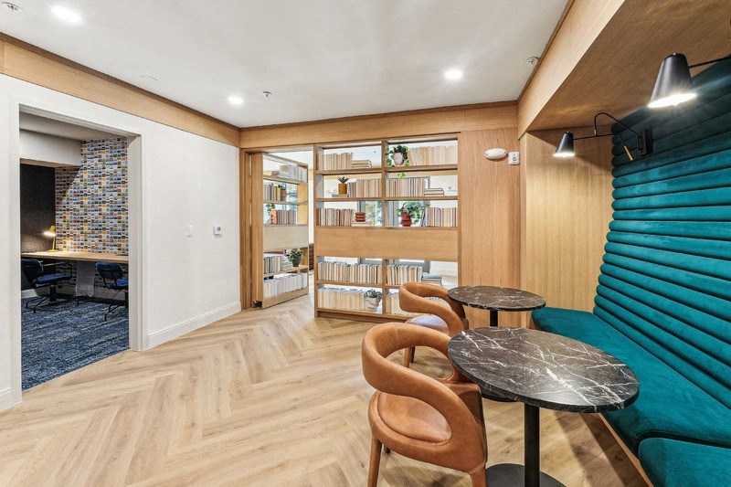 a living room with a blue couch and a table with chairs
