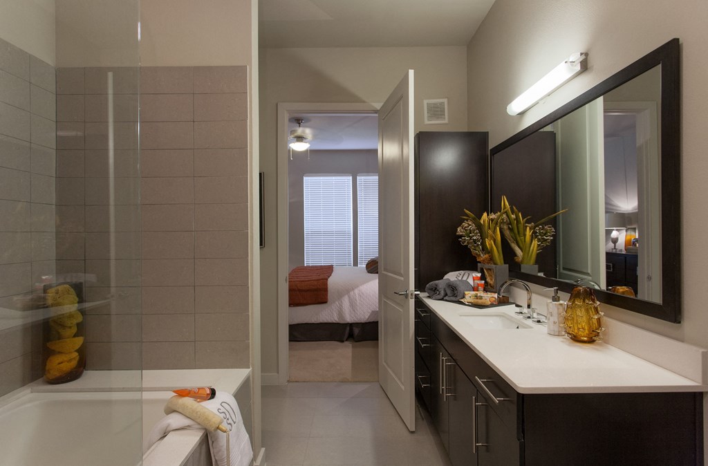A bathroom with a white tub and a white sink.