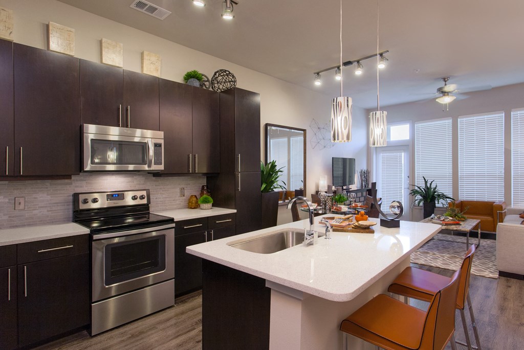 A modern kitchen with dark brown cabinets and a white island.