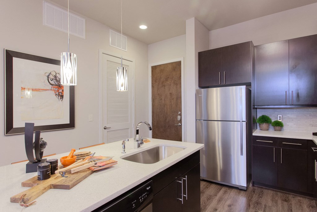 A modern kitchen with a stainless steel refrigerator and wooden cabinets.