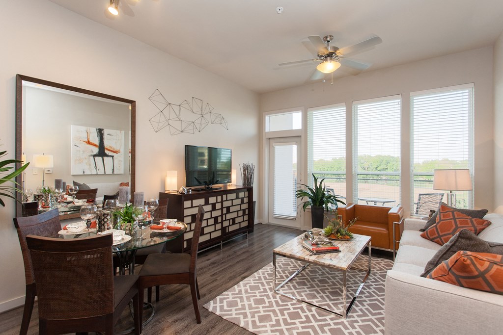 A well-lit dining room with a glass table and chairs.