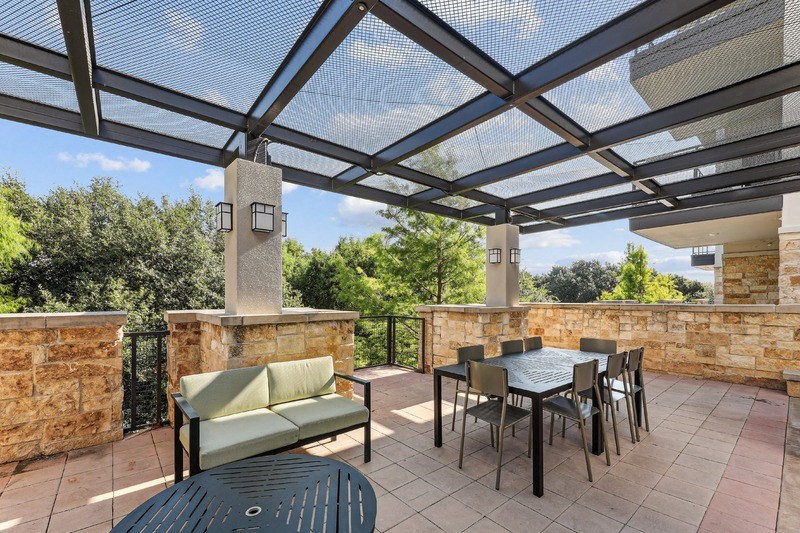 a patio with a table and chairs under a roof